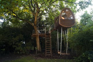 Dubbed the Nut Room, this darling tree house sited in the backyard of a terraced property in Germany was inspired by the old yet vital oak tree that anchors the connected terrace. In order to expose the host tree to as little strain as possible, the team built an independent static system for the structure. The house was prefabricated off-site before being lifted over the main residence with a large mobile crane during the assembly.