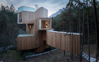 The exterior is vertically clad in timber to complement the spiraling design and surrounding red cedar trees.