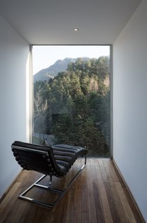  A minimalist reading room sits atop the structure and frames the lush mountain view.