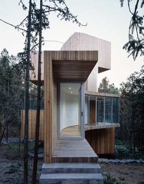 A glass-encased entrance hallway extends outward to meet guests before leading to the central tower and staircase.