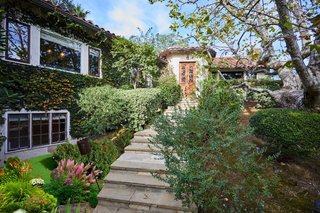 A lush landscape and ivy-covered entrance awaits prospective buyers.