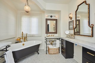 The marbled master bath offers a clawfoot soaking tub and black design accents throughout.