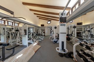 Exposed wooden beams continue into the estate's well-equipped gym.