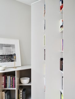 The staggered shelves define the space, wrapping around the perimeter of the home while appearing as a series of columns that project outwards at an angle. 