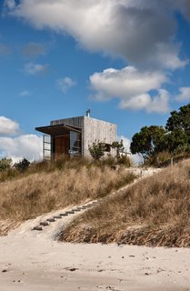 Perched quietly on the dunes of New Zealand’s Coromandel Peninsula, Hut on Sleds serves as a small, sustainable beach retreat for a family of five.