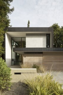 Clad in zinc, stucco, cedar, and glass, Tree House by Aidlin Darling Design is a slender, two-story home composed of interlocking rectangular volumes, and fronted with a low-lying garage.