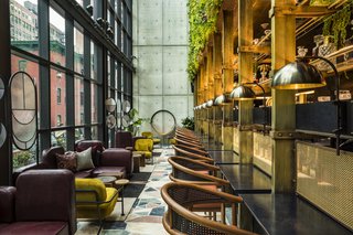 On the other side Bar Feroce on the second floor is the light-filled Conservatory, which occupies a three-story, glass atrium hugging the building’s street-facing side. Across from the glass, a teeming plant wall inspired by Little Shop of Horrors allows the Flower District to infiltrate the hotel. By day, it’s a refreshing space to hold meetings or have an afternoon snack; by night, it’s a cocktail lounge complete with a DJ booth that descends from the ceiling.