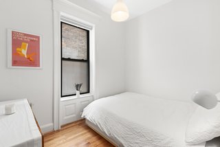 A peek at the second bedroom. Despite its small size, the space feels larger thanks to the home's high ceilings.