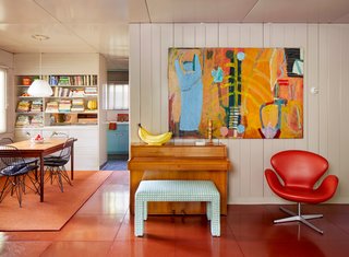 Vibrant red Masonite tiles line the floors in the dining and living areas, delightfully contrasting with the neutral color palette of the interior walls and ceilings. 