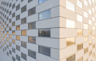 The facade is composed of 4,800 concrete slabs interspersed with glass. 