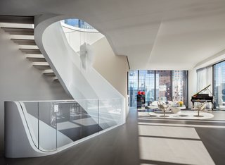 Designed inside and out by Zaha Hadid, the penthouse features the famed architect's signature curves throughout. Each level is united by a sculptural white staircase.