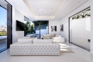 Dressed in all white, the corner living room offers ample seating while framing stunning views.