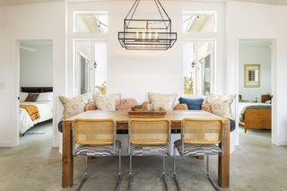 Strategically placed vertical windows behind the built-in banquette usher in ample natural light to illuminate the central dining area.