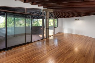 A dramatic wood-beamed sunburst ceiling takes center stage in the living room. Large sliding doors lead to a spacious open-air terrace, complete with views of the San Fernando Valley.