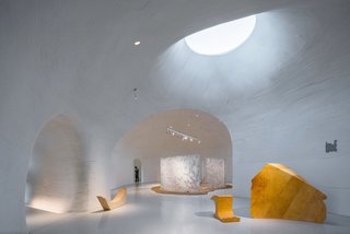 After passing through a long, dark tunnel and a small reception area, guests are welcomed into the largest gallery, which leads to other cave-like spaces.