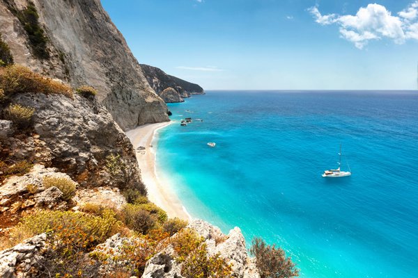 A wash of muted colors pops against the turquoise and teal Aegean Sea.