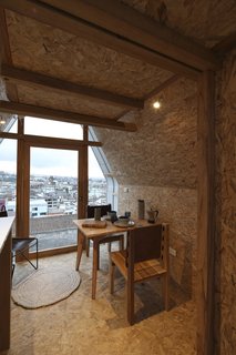 A small dining table is situated near the front door for city views during breakfast or dinner. 