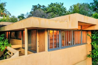 The original golden stucco was restored by a previous homeowner. Schindler's "plaster skin" facade and experimentation with differing rooflines are distinct features of the design.