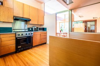 Sunlight dramatically descends into the kitchen from additional clerestory windows. The space has been modernized with period-appropriate cabinetry and professional-grade appliances.