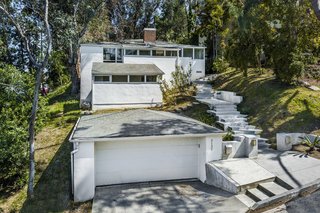 The exterior of the historic residence at 3132 Oakcrest Drive is simple and clean. A sloping roofline follows the topography of the 8,000-square-foot lot.