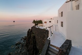 The home's expansive terraces look out over panoramic views of the <span style="font-family: Theinhardt, -apple-system, BlinkMacSystemFont, "Segoe UI", Roboto, Oxygen-Sans, Ubuntu, Cantarell, "Helvetica Neue", sans-serif;">Tyrrhenian Sea.</span><span style="font-family: Theinhardt, -apple-system, BlinkMacSystemFont, "Segoe UI", Roboto, Oxygen-Sans, Ubuntu, Cantarell, "Helvetica Neue", sans-serif;"> Stairs lead down along the stone retaining wall to the rocky shore below. <br></span>