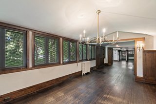 A 22-foot long dining area is revealed once through the entry way. Diamond leaded glass windows run along the wall, complemented by wooden trim and a pitched ceiling. 