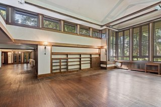 A dramatic two-story living space is the heart of the home. Seven-foot-tall bookcases envelope the room, which, along with the dark wooden floors, lends a library-like atmosphere.