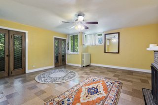 A large bedroom upstairs opens up onto an enclosed porch and offers one of the three fireplaces. The diamond leaded glass windows run throughout all of the spaces.
