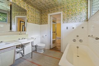 One of three full bathrooms, the spacious area offers a soaking tub and access to the bedroom. A large window brings natural light into the space.