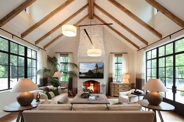 The Country French style is more apparent in the family room, which features a cathedral ceiling strapped with wooden beams. Natural light seeps into the space from large windows and doors along both sides of the room, as well as dormer windows along the ceiling.