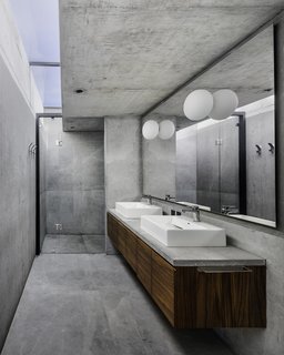 The concrete master bathroom is illuminated by a skylight.