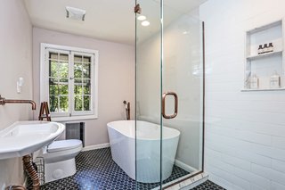 The only full bathroom is also located upstairs. A complete renovation included new tile, a stand-alone soaking tub, and a walk-in shower.