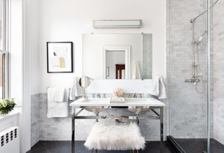 The windowed master bath features Nero Marquina marble flooring, Carrara marble dual sinks, and a glass standing shower. The bath fixtures are nickel plated.