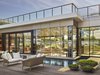 A shimmering “glass house” sits at the center of the property. Inside is the “drawing room,” an inviting spot for drinks, dining, or planning the day’s activities. Beyond it is the hotel’s grass dune garden, designed by Madison Cox Associates. Photo 4 of Asbury Ocean Club Hotel modern home