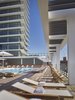 Teak lounges and chairs surround the pool area, which overlooks the ocean. The residential tower is visible in the background. Photo 6 of Asbury Ocean Club Hotel modern home
