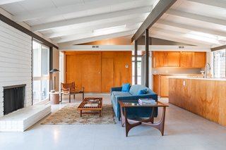 All of the home's signature windows and doors are still intact, as is the rich original Birch paneling and post-and-beam construction. An atypical VCT tile lines the interior flooring.