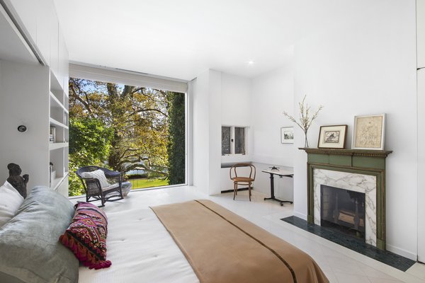 In total, the townhouse offers four bedrooms. Here is a look at the master bedroom, complete with built-in bookshelves and a fireplace that includes the original mantel and marble inlay.