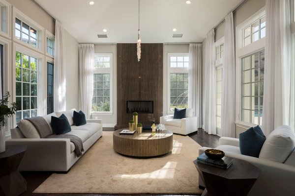 A contemporary fireplace is a modern take on the traditional stone focal point. The light-filled space is also enclosed by three walls of picture windows, inviting in plenty of natural light.