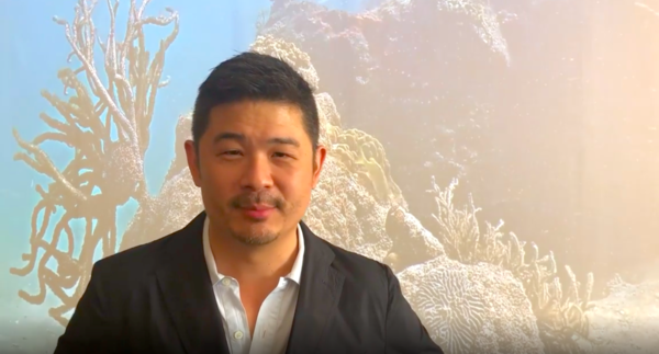 Design Miami's curatorial director, Aric Chen, in front a work by Coral Morphologic, a Miami duo who have placed a live webcam in a coral reef that is thriving in the busy urban waters of Biscayne Bay.