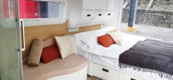 Next the the couch is a bed with built-in storage and a wardrobe. Aluminum alloy&ndash;framed windows grant one-way views of the outdoors.