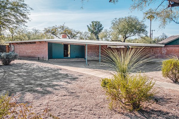 An angular car port juts out and away from the entryway, keeping parked cars cool in the desert heat.