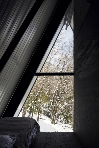 Rustic stairs lead to a pair of dormitory-style bedrooms with west-facing windows.