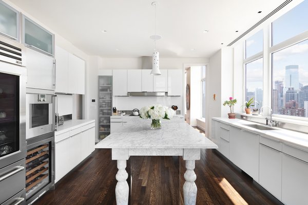 Steps away from the living area is a bright and airy chef's kitchen. Boasting custom Poggepohl white-lacquer cabinetry and white-honed Carrera marble countertops, the kitchen also comes with a Gaggenau dishwasher, stainless-steel convection and steam ovens, as well as a SubZero wine cooler and refrigerator. 