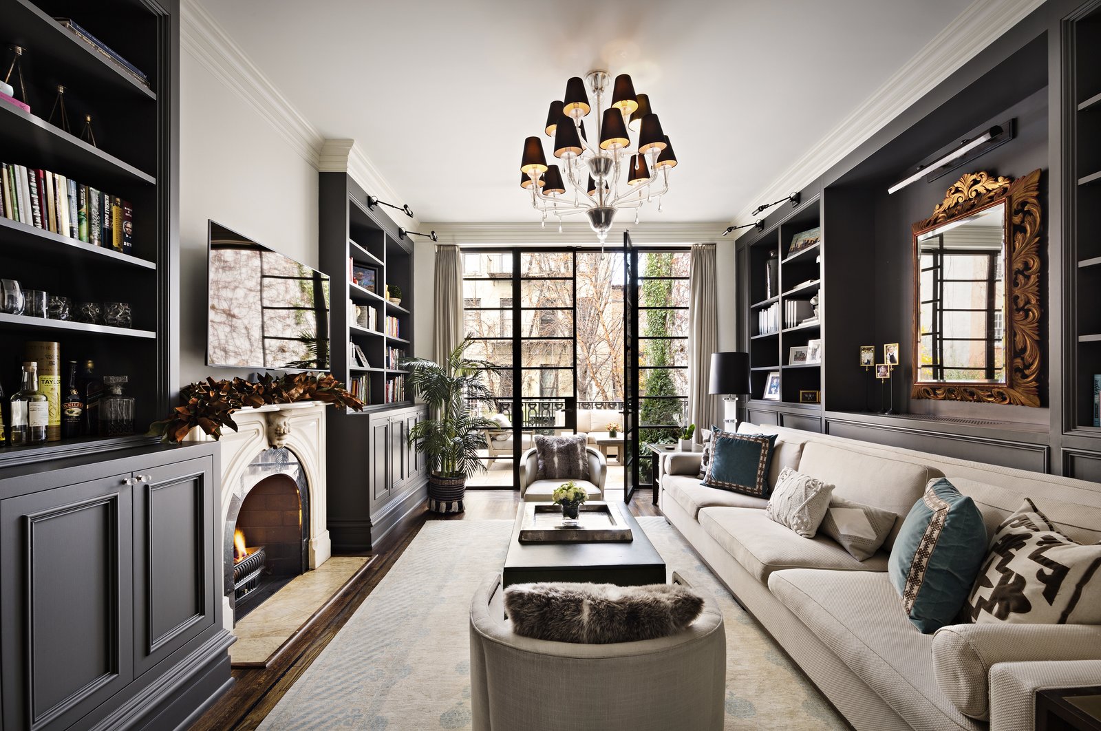 Beyond the living room is an inviting library. Tasteful built-ins flank the gas fireplace, while a long, plush sofa provides ample seating for gathering. 