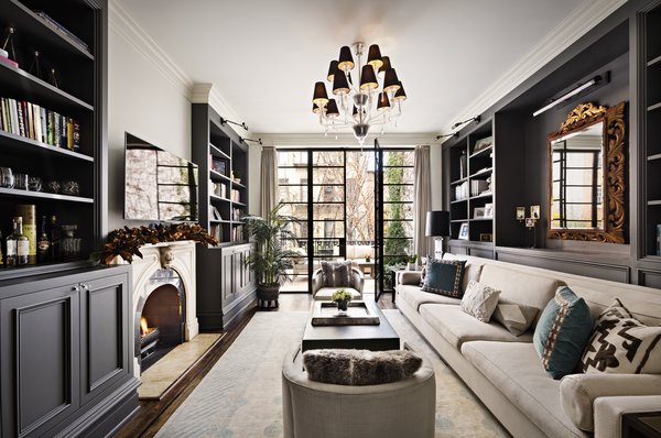 Beyond the living room is an inviting library. Tasteful built-ins flank the gas fireplace, while a long, plush sofa provides ample seating for gathering. 