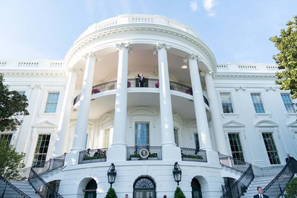 President Donald Trump stands on the White House balcony.