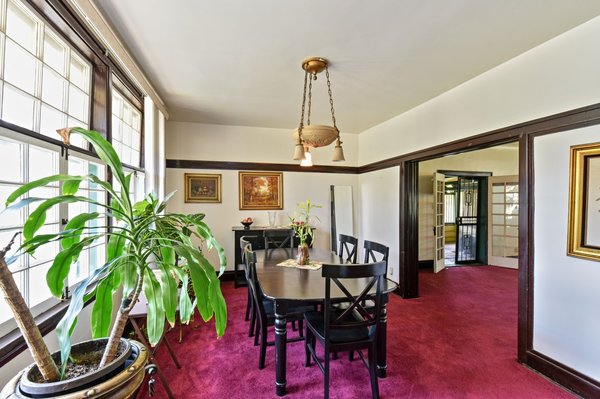 A formal dining area off of the living room basks in natural light from windows stretched along the front and overlooking the lawn.