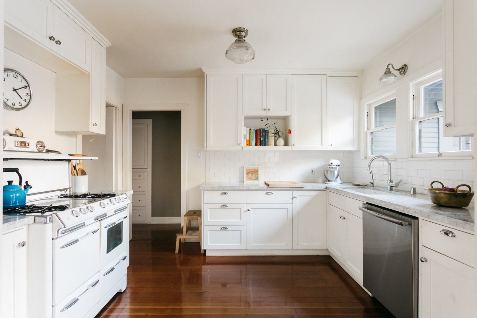 A Vintage Stove Awaits In The Kitchen Along With Stone Countertops And Ample Cabinetry Windows Above The Sink Overlook The Backyard 