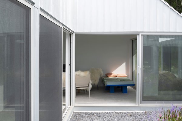 The exterior is clad in Galvalume siding, a workaday, weather-resistant material that gives the facade a shimmer that varies depending on the light.