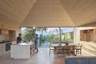 The interior of the house is lined in pine. Anchoring the dining area are an antique Norwegian farm table and chairs. The appliances are by Gaggenau.